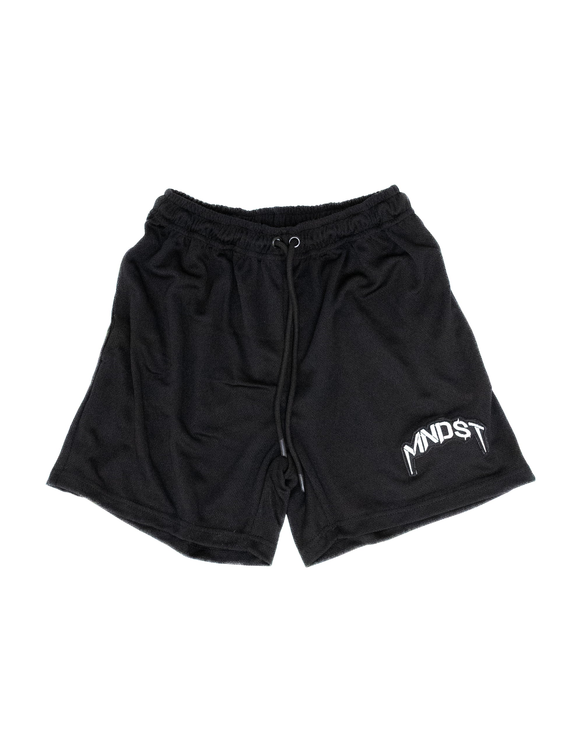 Black shorts with a MNDST logo on a white background