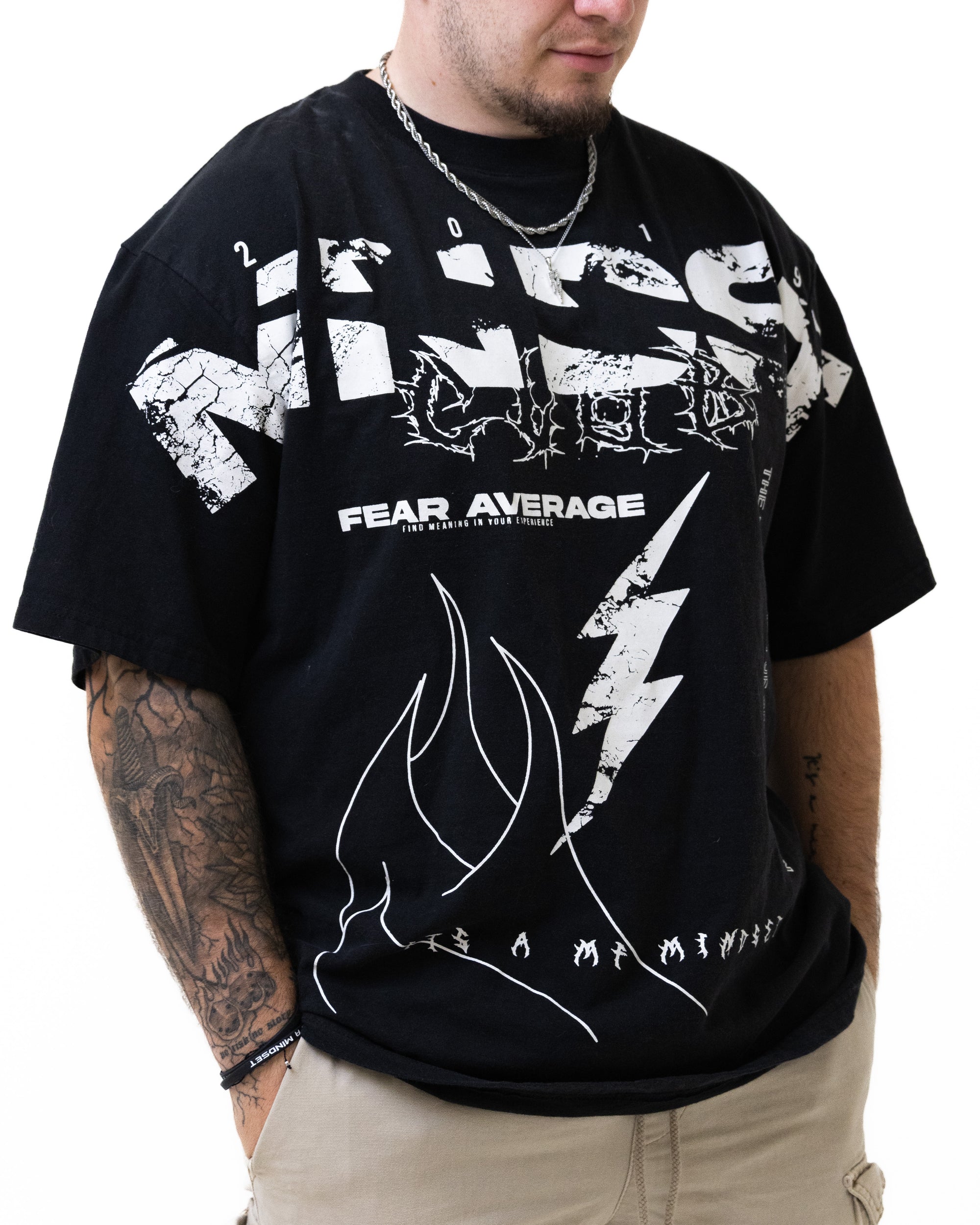 Person wearing a black t-shirt with white graphics and text on a white background