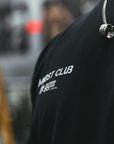 Black t-shirt with 'MNDST Club The Gym' text on a blurred street background