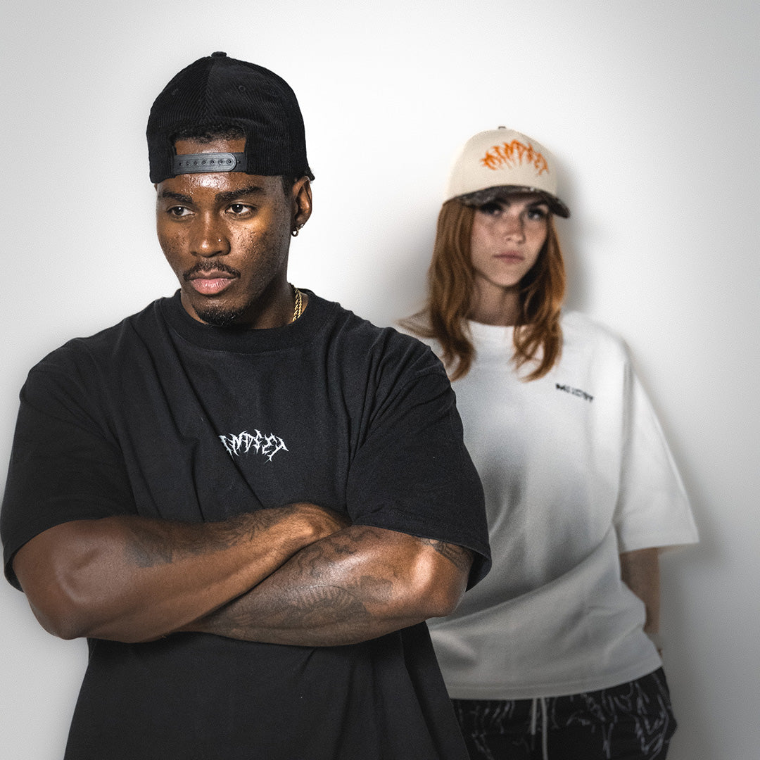 MNDST models showcasing the Revelations Tee and Legacy 6-panel hat.