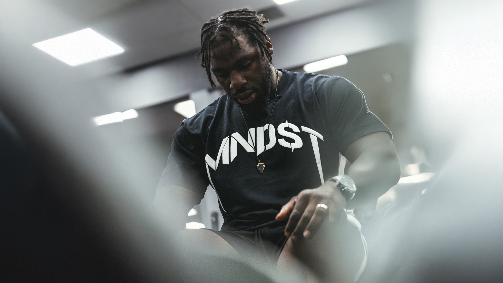 Person wearing a black t-shirt with 'MINDST' text in a gym setting