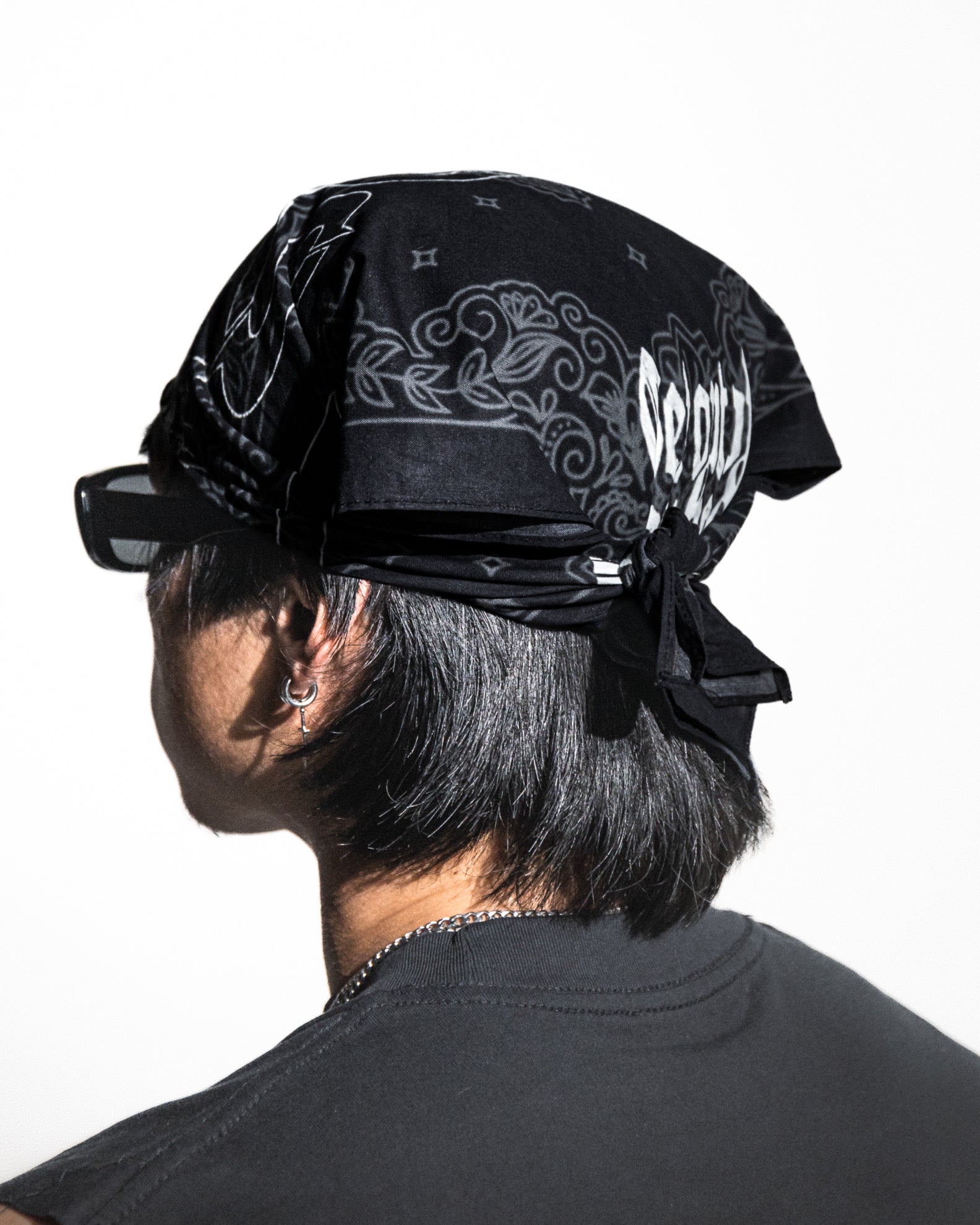 Person wearing a black bandana with white text on a white background